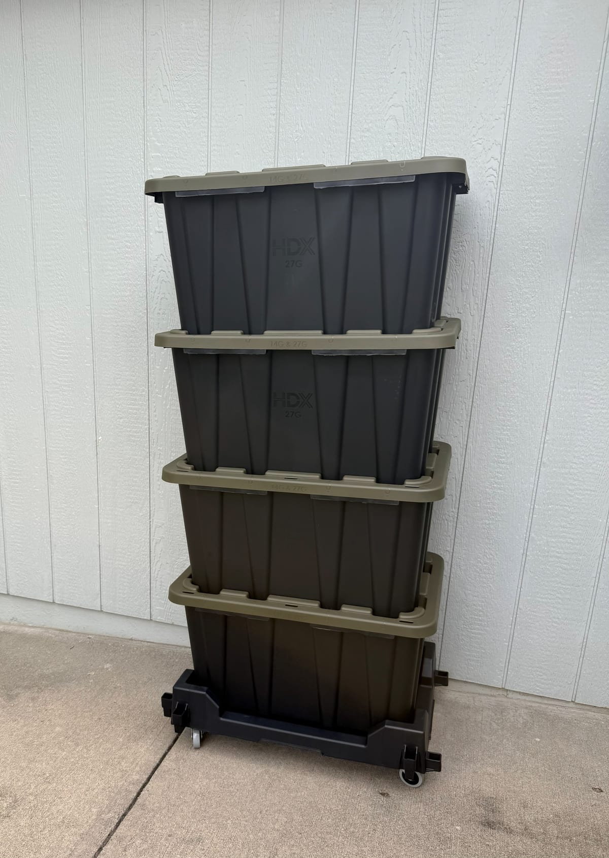 A stack of our black totes with green lids sitting on a Tote Taxi rolling cart